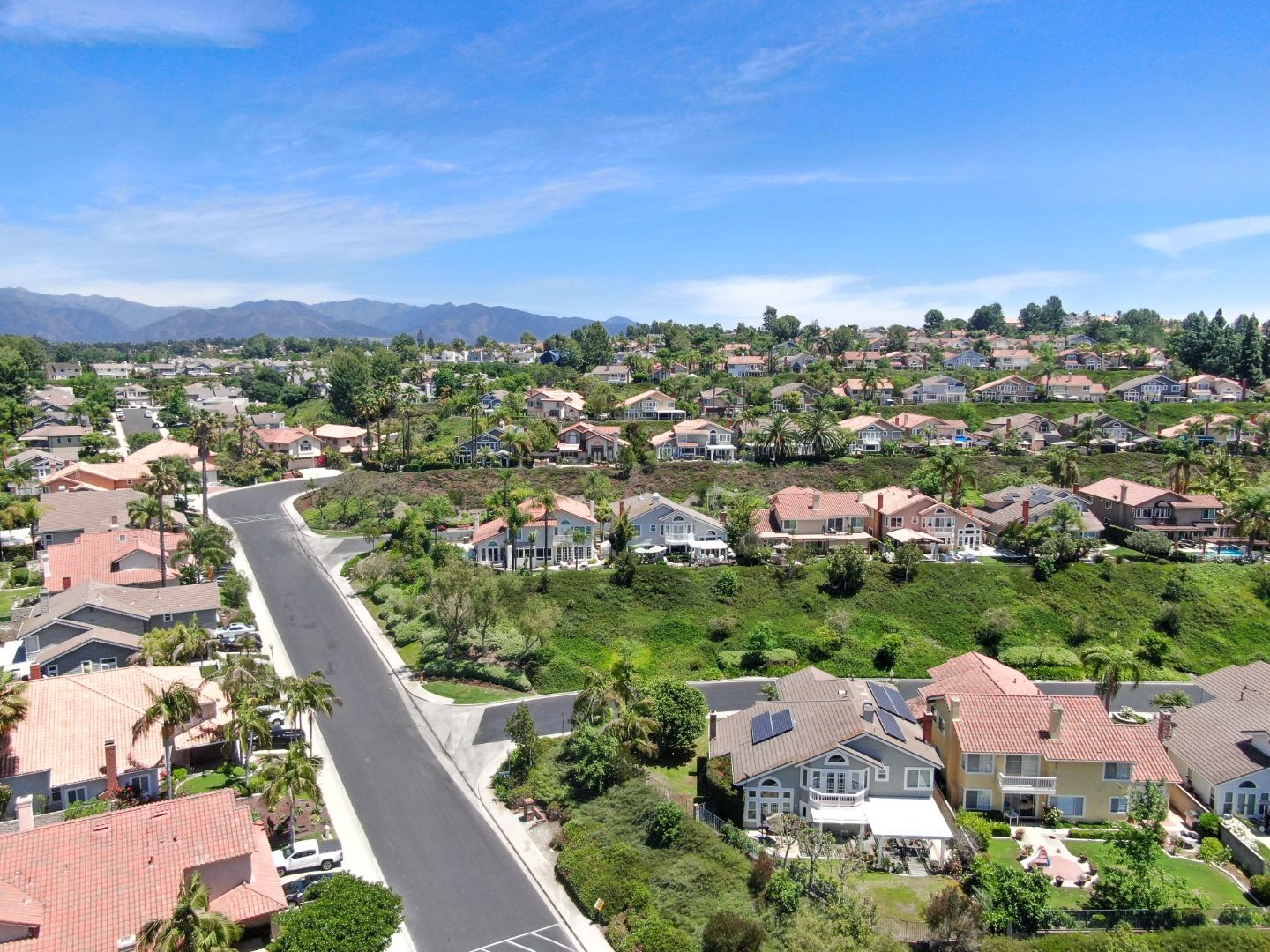 Aerial view of a master-planned Mission Viejo community with hillside homes and pools